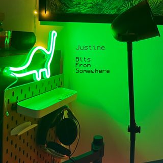 A photograph a green neon shining on my wall, in the shape of a dinosaur.